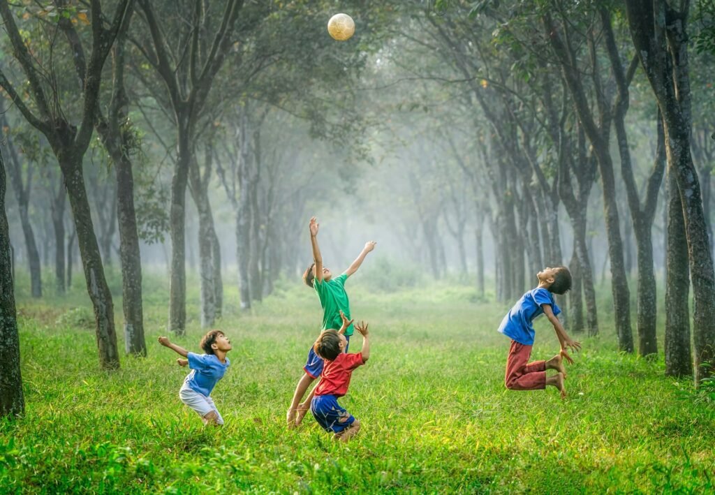 children playng in the green ground with football